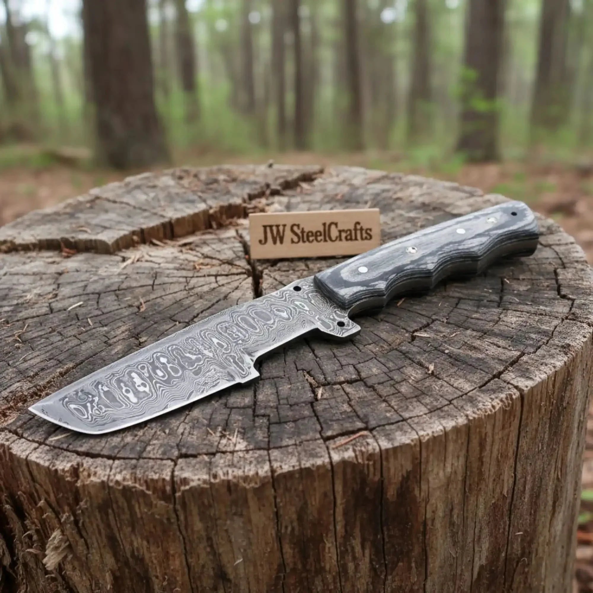 Handmade damascus steel knife with premium handle on dark surface