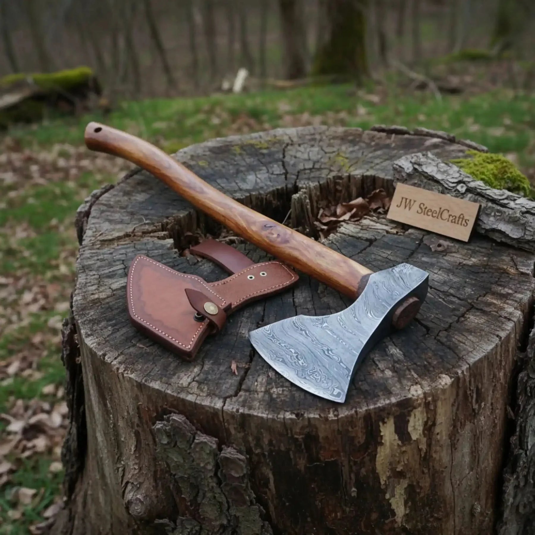 Damascus steel axe head with wood handle on rustic wood surface