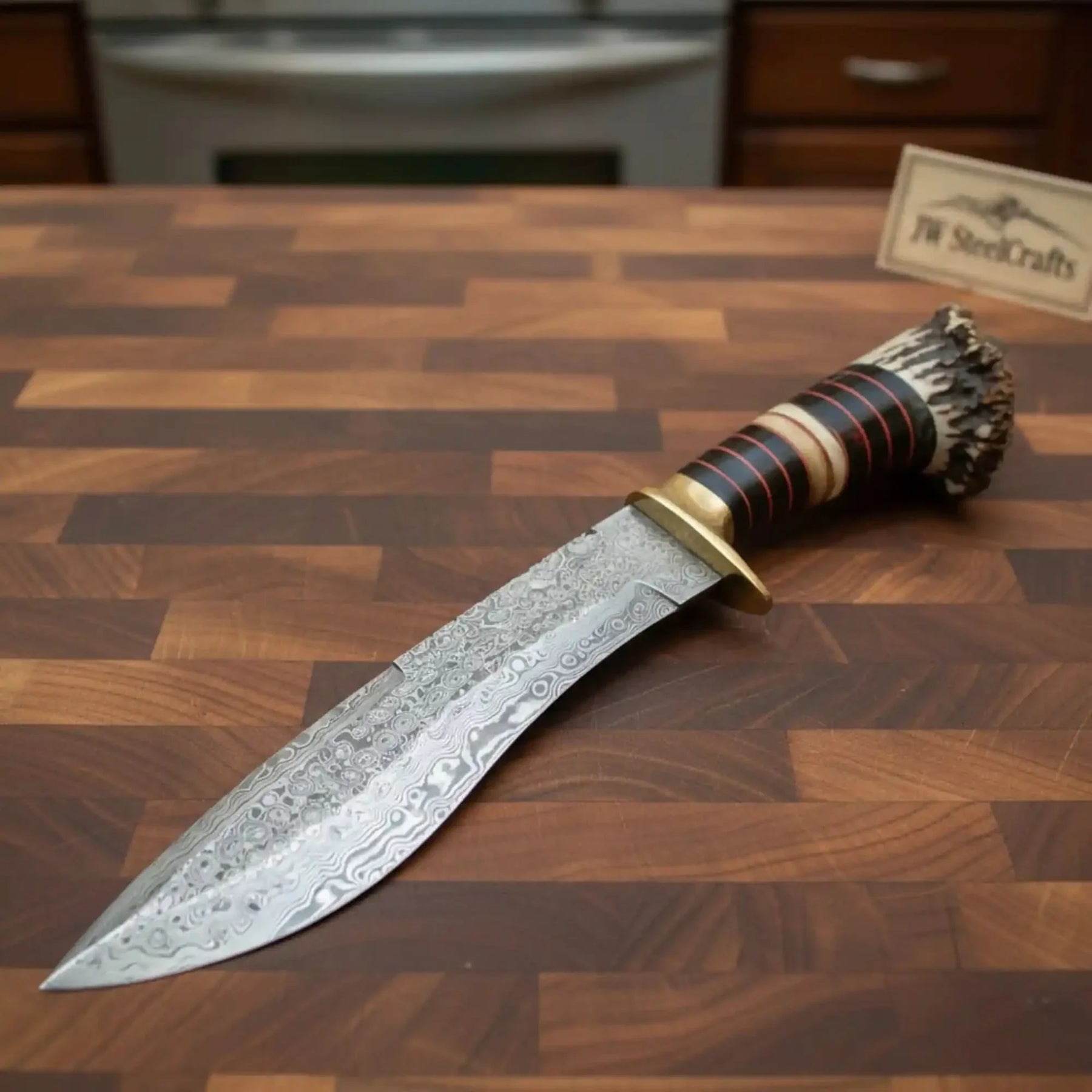 Handmade damascus steel knife with horn handle on dark surface
