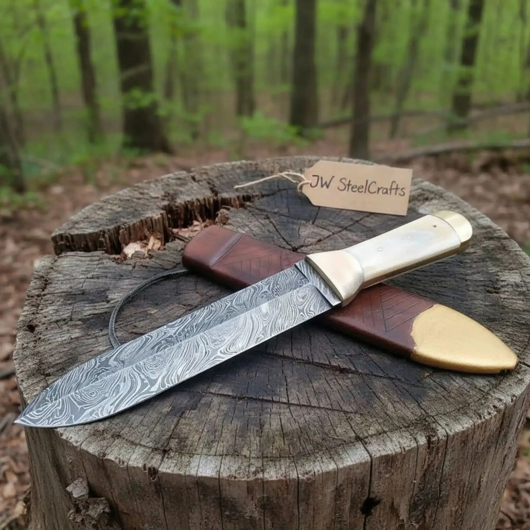 Handmade damascus steel knife with wood handle on dark surface