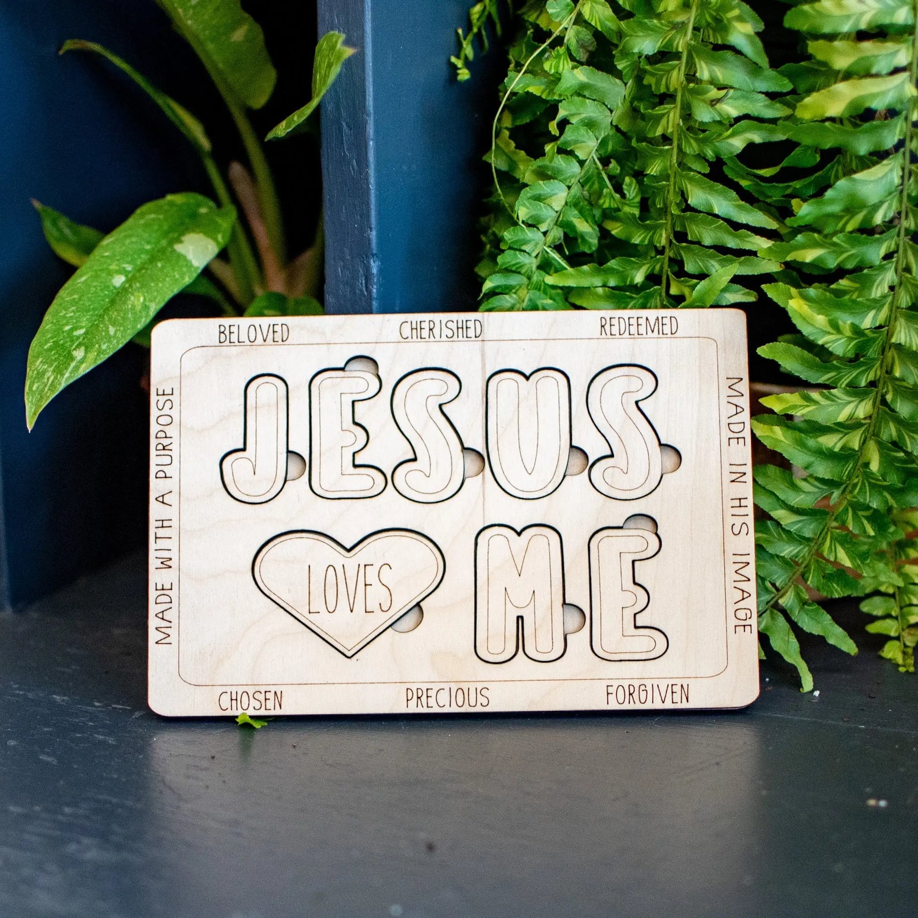 Wooden "Jesus Loves Me" puzzle with block letters and a heart shape.