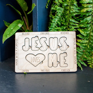 Wooden "Jesus Loves Me" puzzle with block letters and a heart shape.