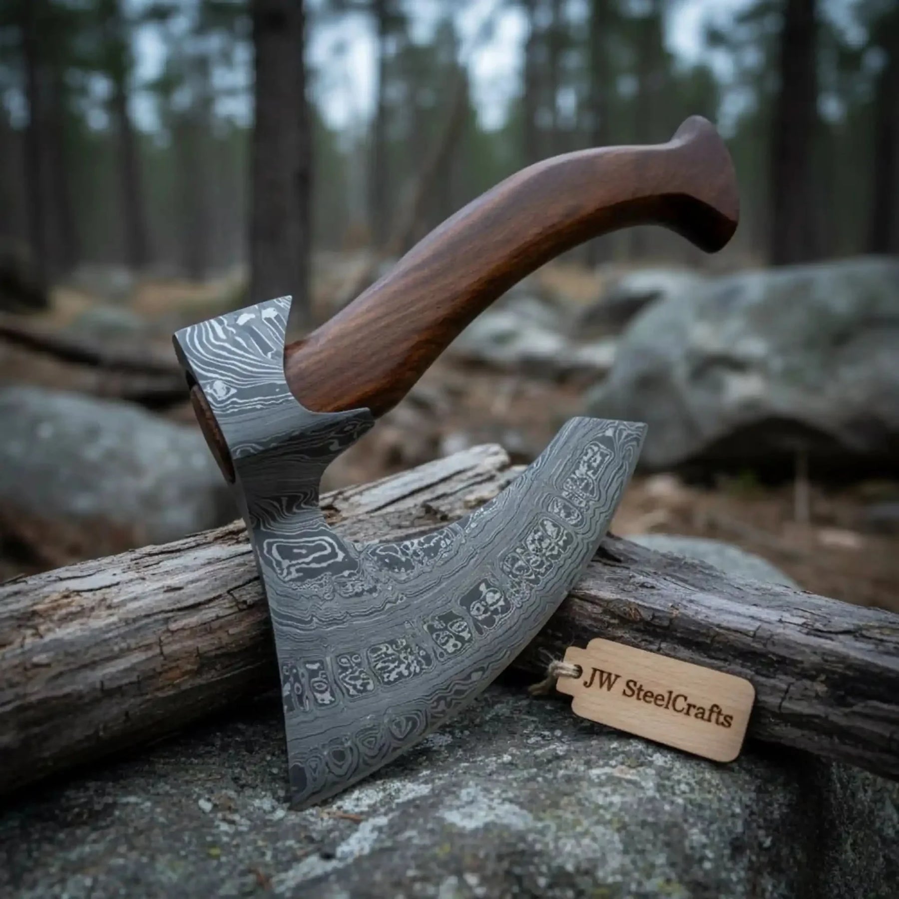 Damascus steel axe head with wood handle on rustic wood surface