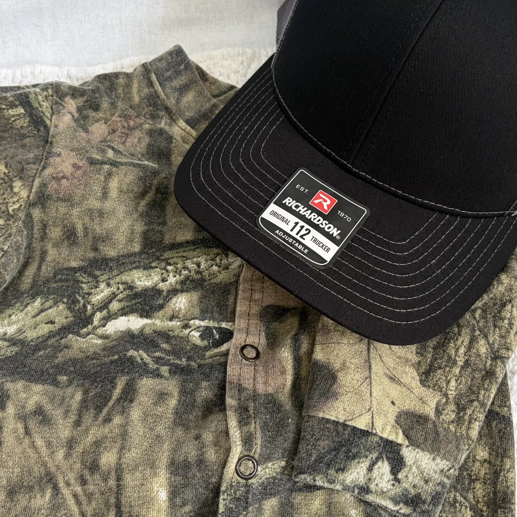 Custom keepsake hat with camouflage fabric and Richardson trucker cap label.