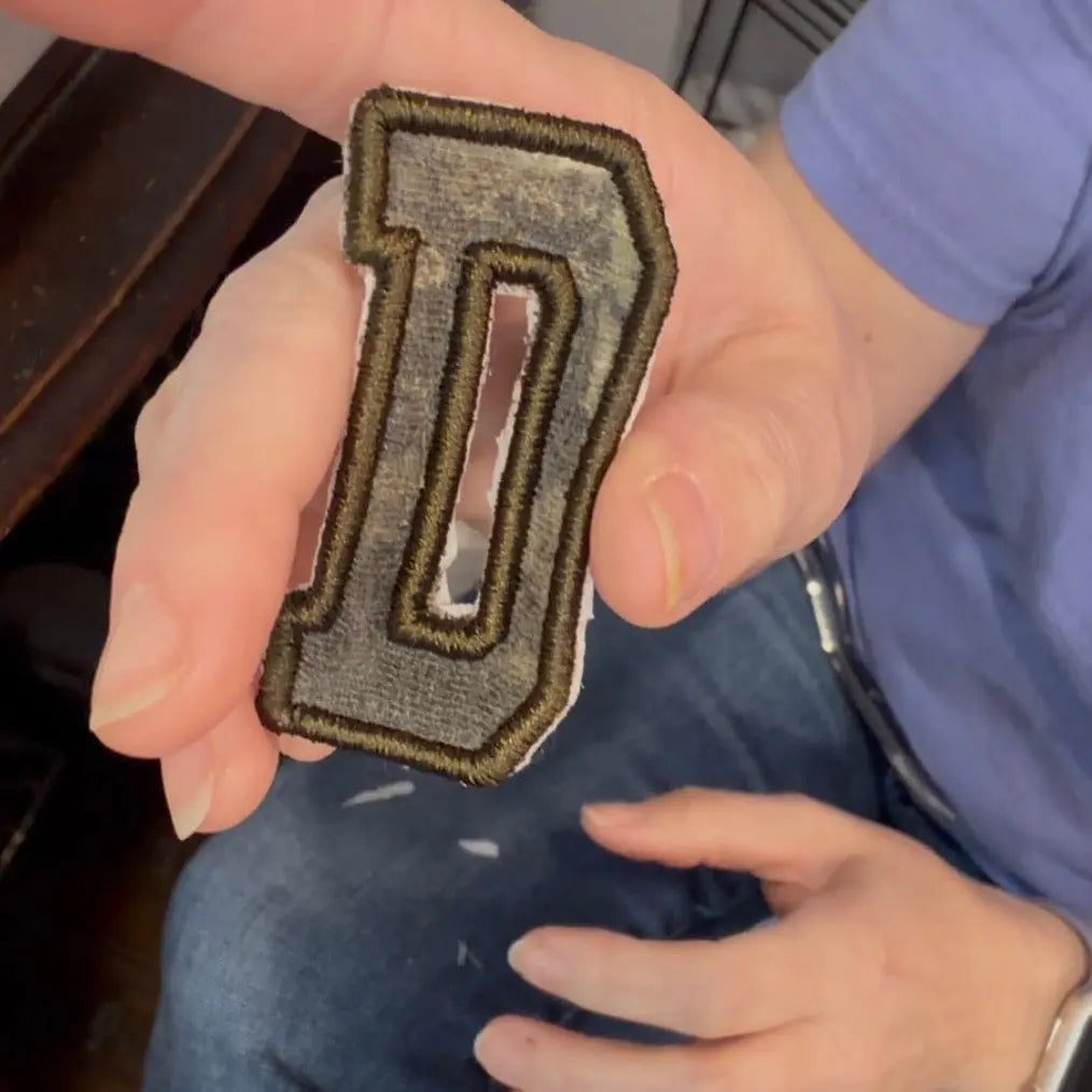 Custom embroidered letter D appliqué patch from baby clothes.