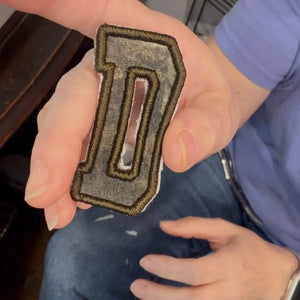 Custom embroidered letter D appliqué patch from baby clothes.