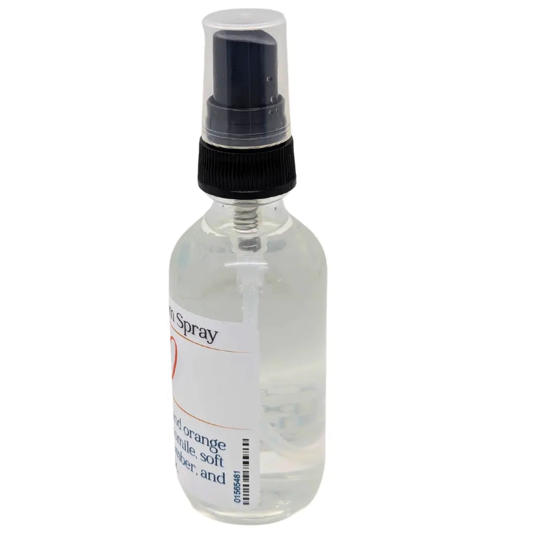 Clear glass spray bottle with black nozzle and Kudzu ResilMist label, showcasing a room spray.