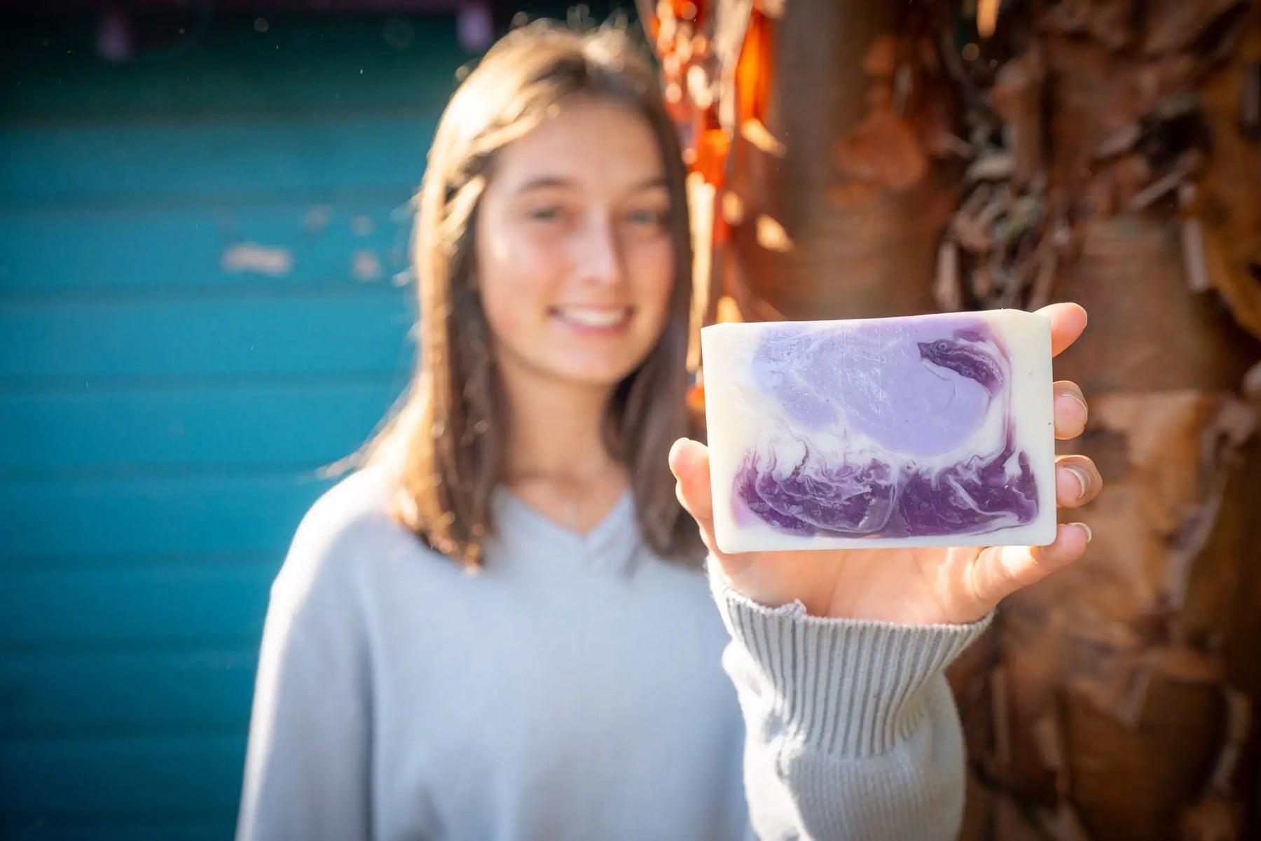 LAVENDER GOAT'S MILK SOAP SLICE 5 OZ. with purple swirls held by hand