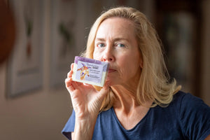 Woman holding a bar of lavender goat milk soap from The Appalachian Goat.