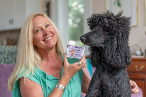 Black poodle with woman holding lavender goat milk soap slice