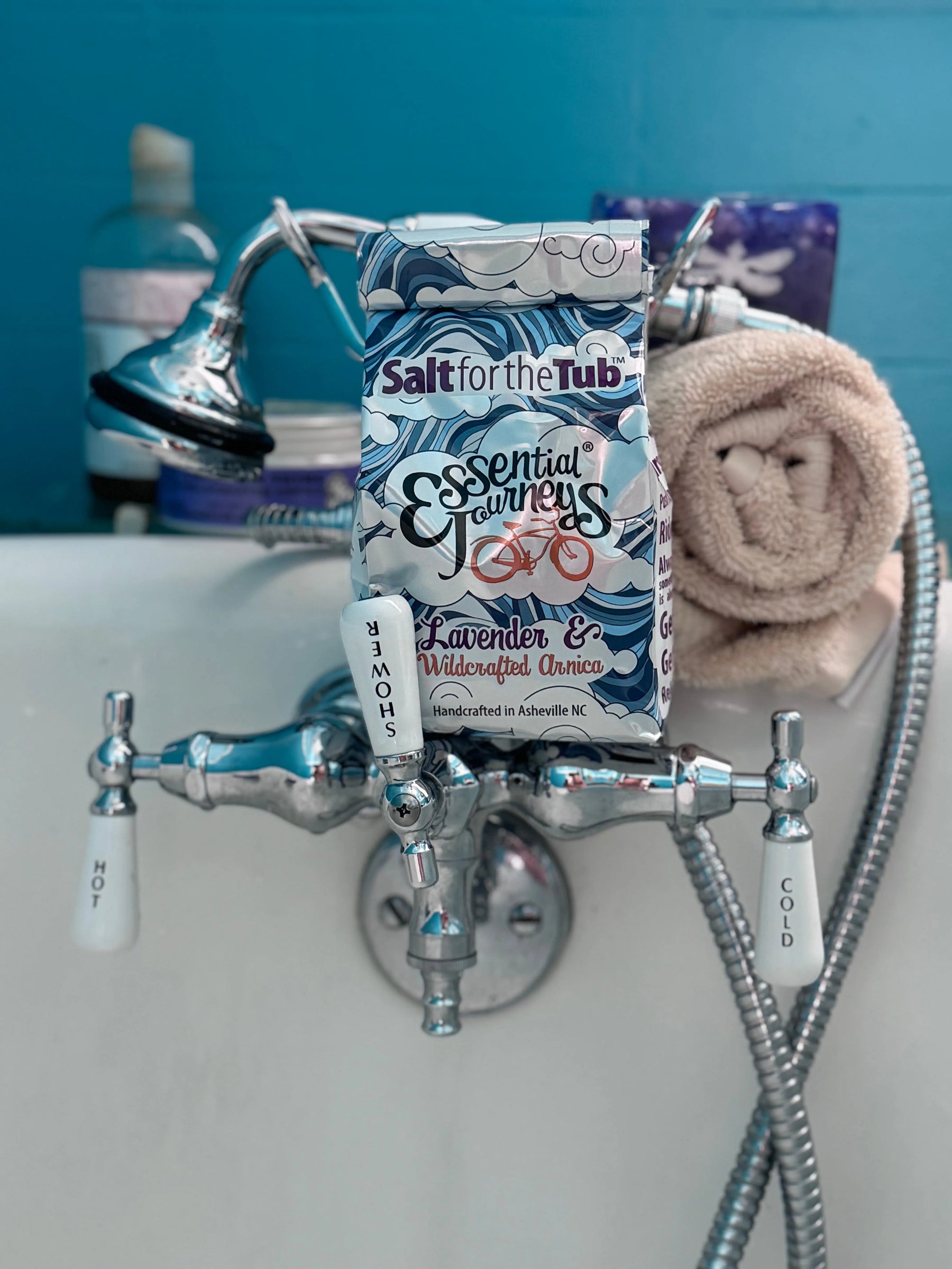 Essential Journeys Lavender & Arnica bath salts packaging in a bathtub.