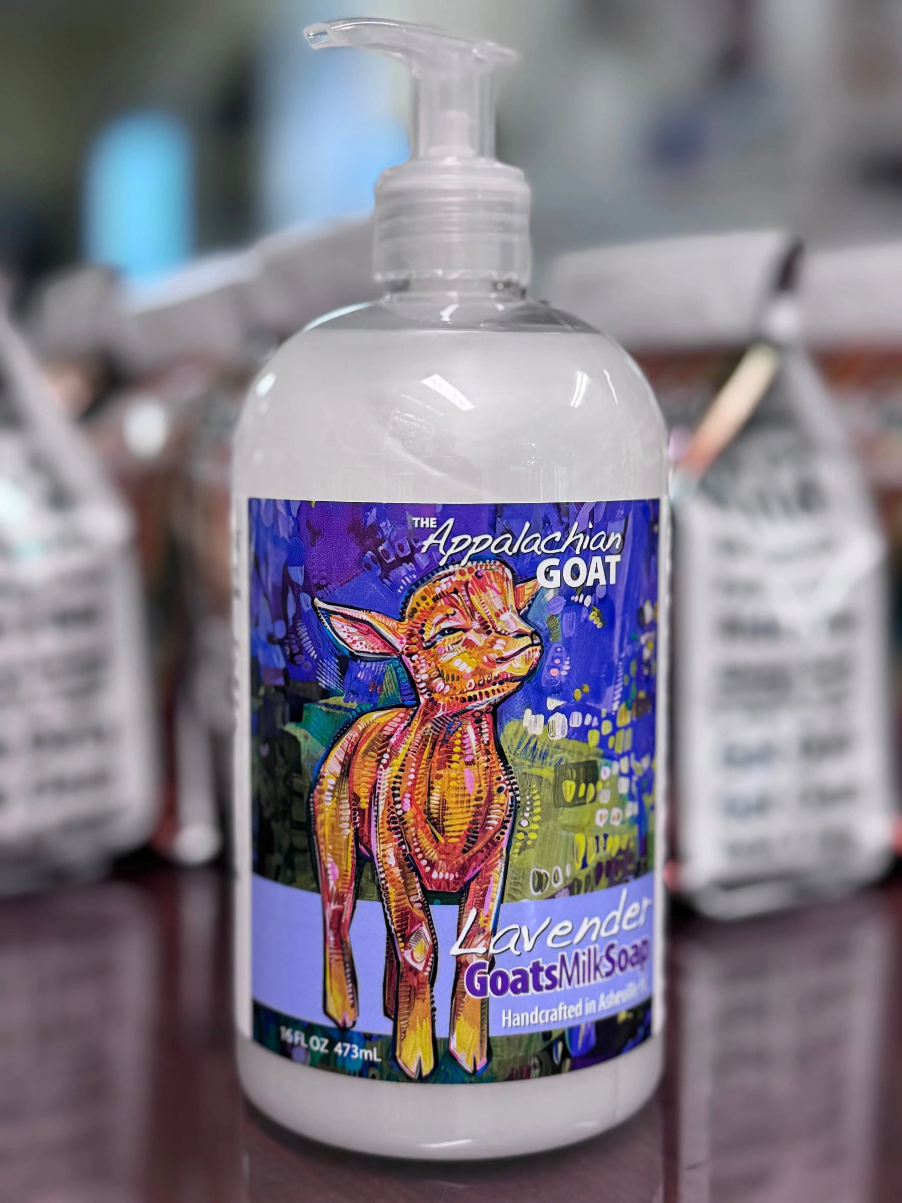 Bottle of lavender goats milk liquid soap with a colorful illustration of a goat.
