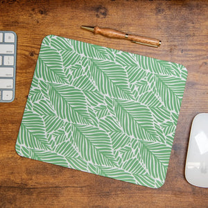 Green leafy pattern mouse pad on a wooden desk.