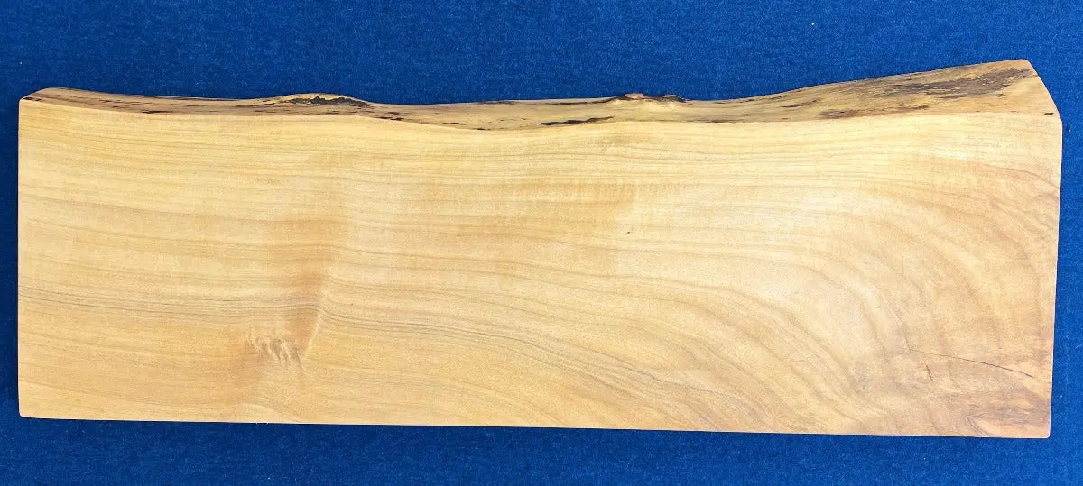 Magnetic wooden knife holder made of light brown wood with natural edges, displayed on a blue background.