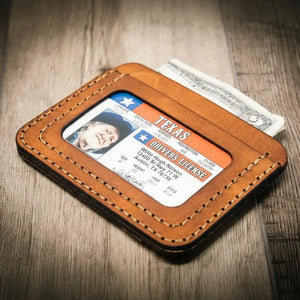 Brown leather wallet holding Texas ID and cash.