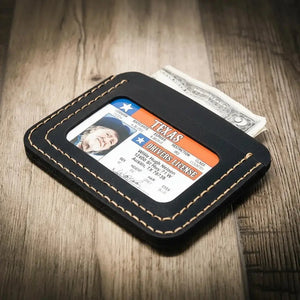 Black leather minimalist wallet with Texas driver's license and dollar bills.