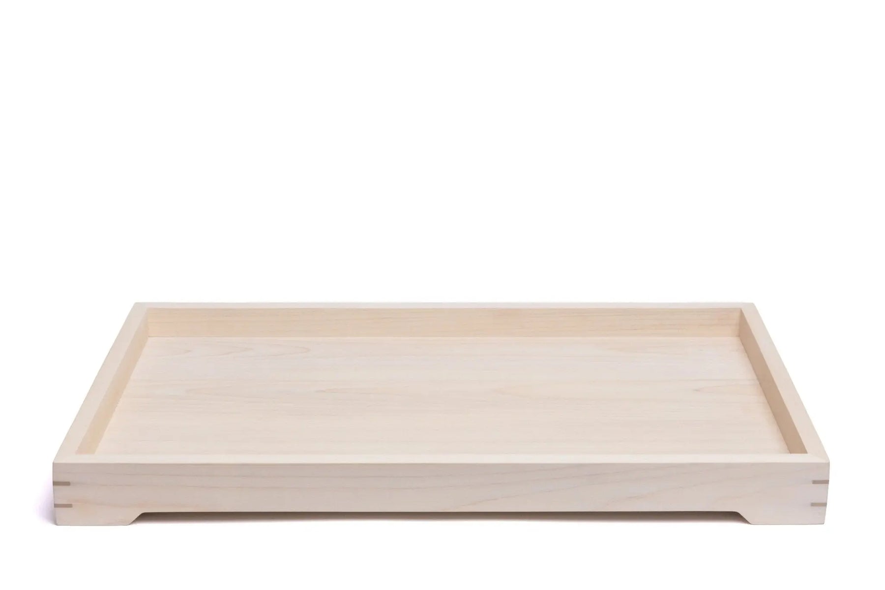 Light-colored wooden tray featuring a rectangular shape and visible wood grain, showcasing simple modern design.