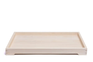 Light-colored wooden tray featuring a rectangular shape and visible wood grain, showcasing simple modern design.