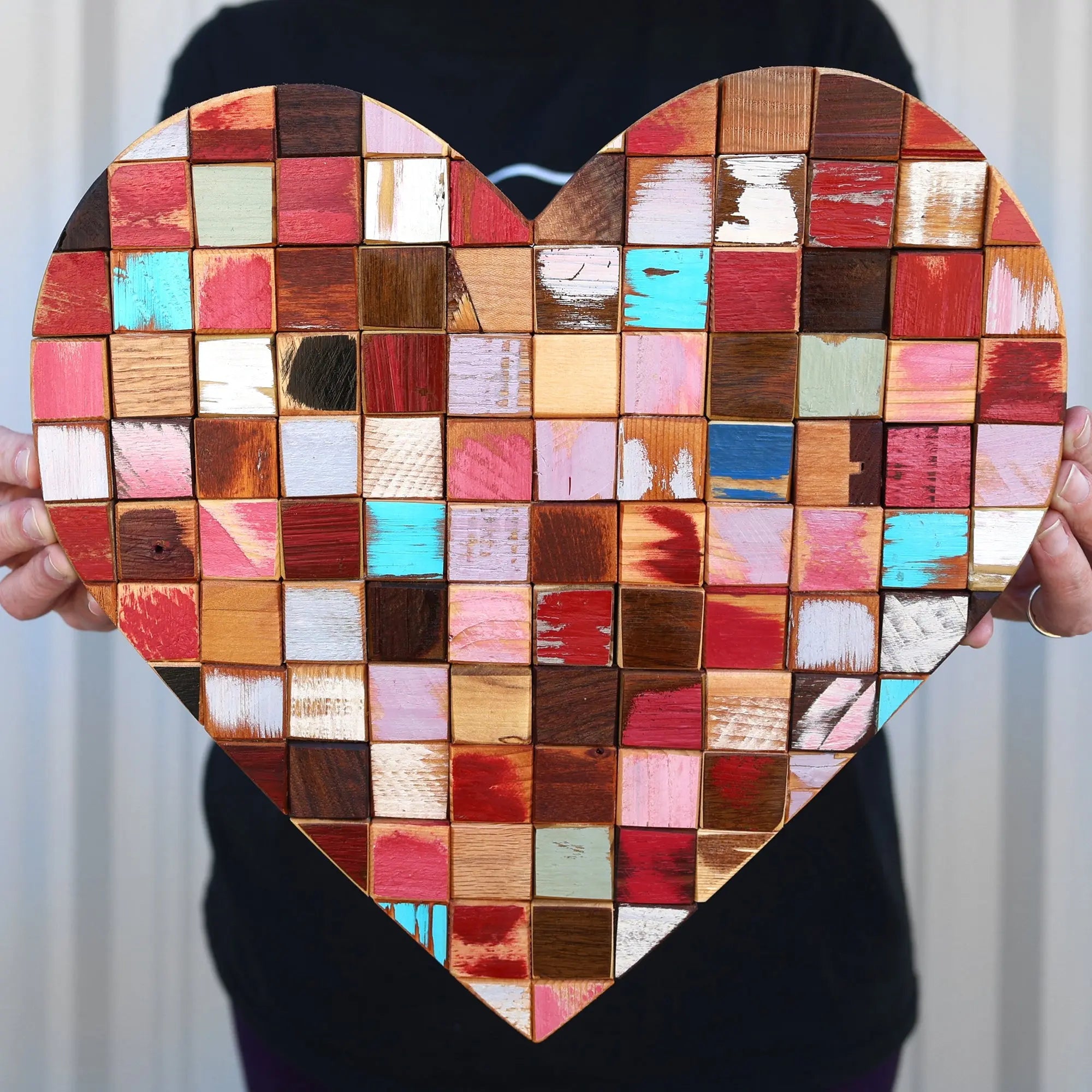 Mosaic heart art made from colorful reclaimed wood blocks.
