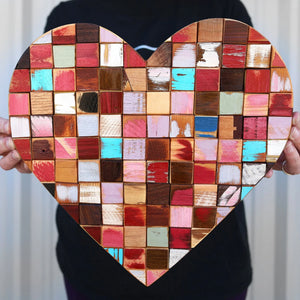 Mosaic heart art made from colorful reclaimed wood blocks.