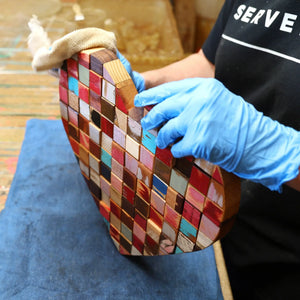 Mosaic heart art being polished with a cloth