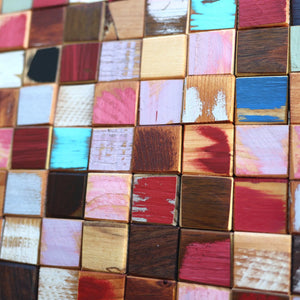 Colorful mosaic of reclaimed wood cubes in various painted finishes.