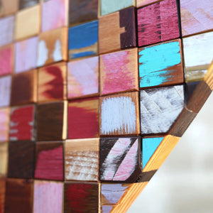 Mosaic heart art made from colorful reclaimed wood cubes.