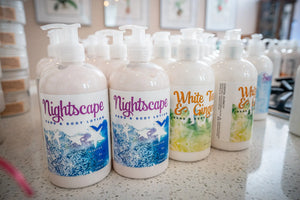 Nightscape Hand & Body Lotion bottles and White Tea & Ginger lotion by Essential Journeys.