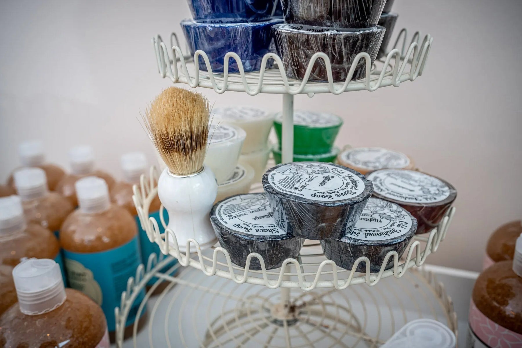Essential Journeys Old Fashioned Men's Shave Soap collection on a white tiered display.