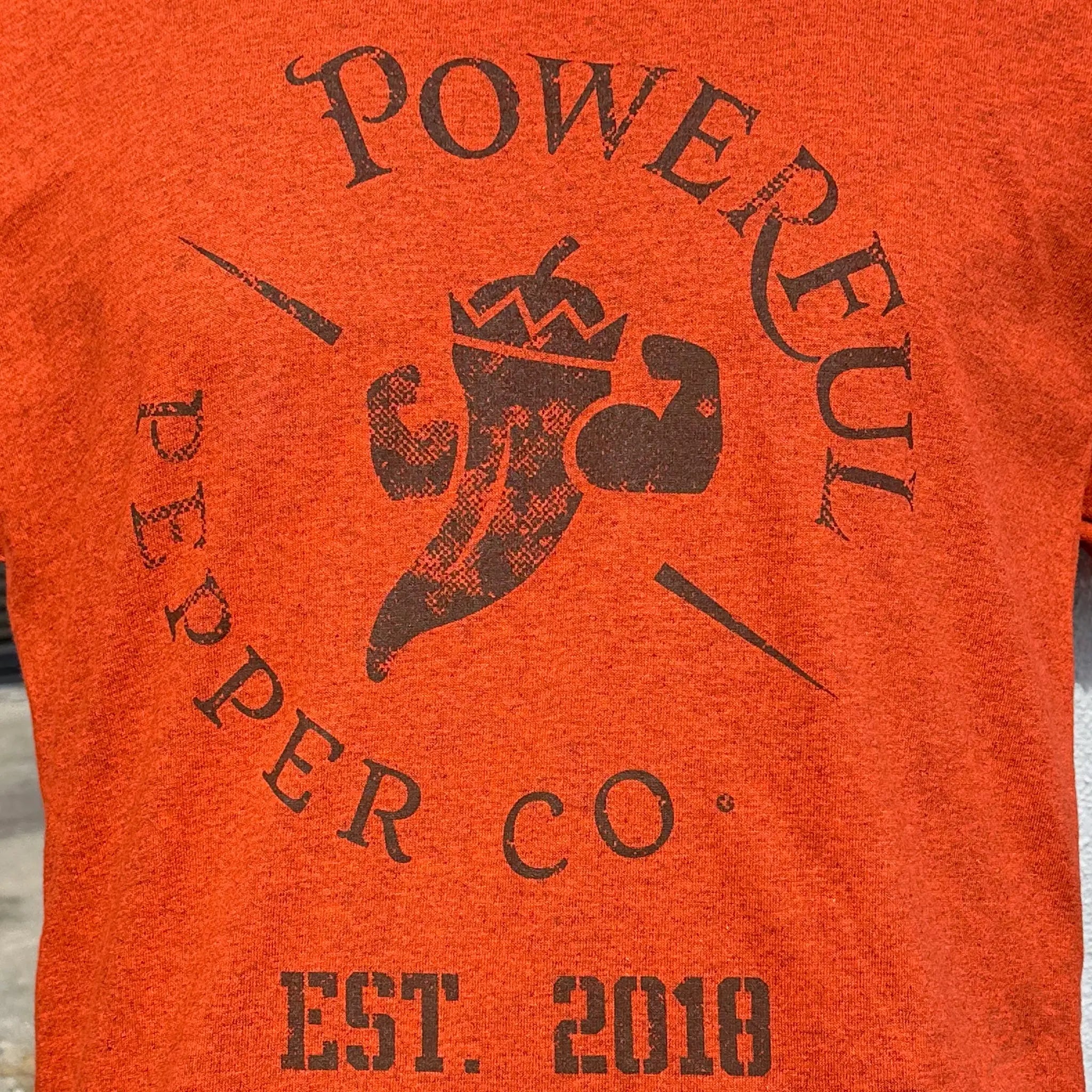 Orange vintage logo t-shirt with Powerful Pepper Co. graphic.