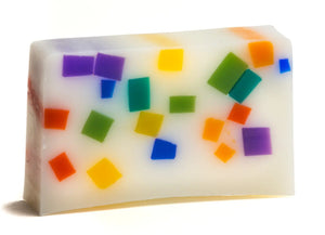 White soap slice with embedded colorful geometric squares in a rainbow pattern.