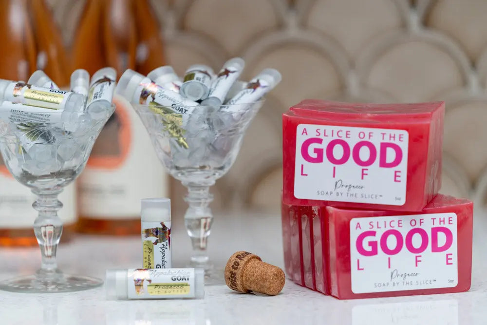 Prosecco soap slices and lip balms displayed with ice in crystal glasses by Essential Journeys.