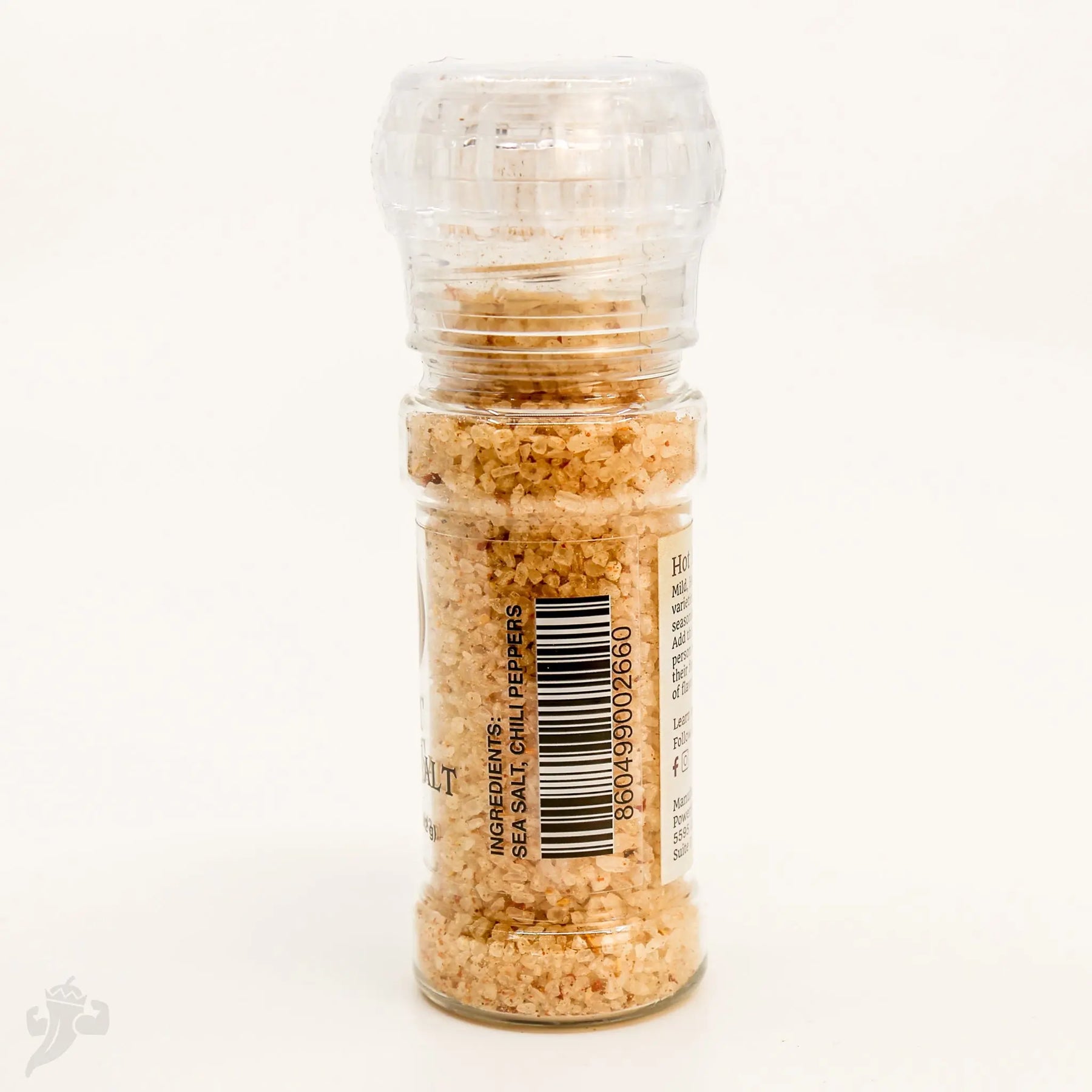 Glass pepper salt grinder filled with sea salt and chili peppers.