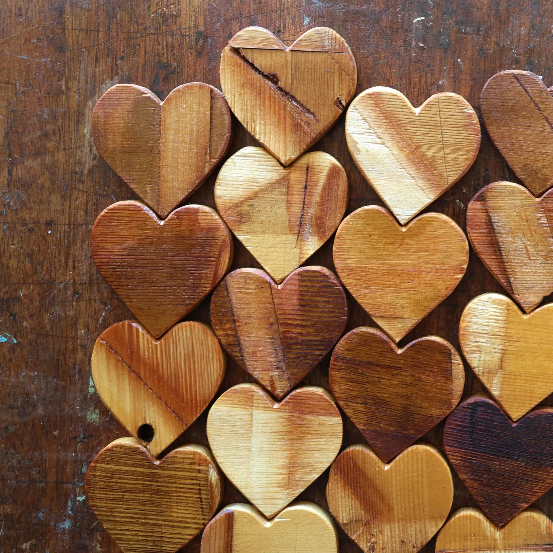Wooden heart shapes arranged on a dark wooden surface.