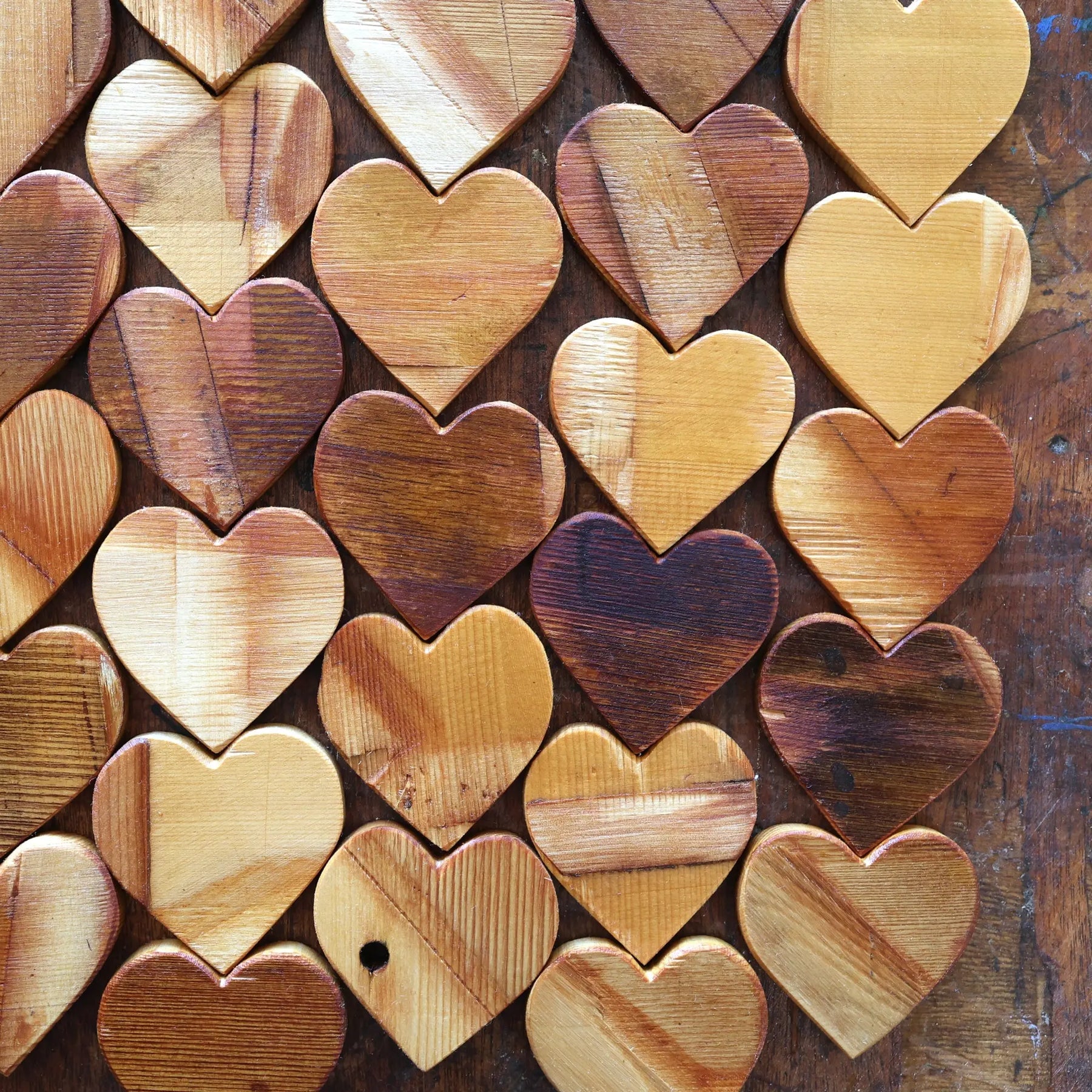 Arrangement of wooden hearts with varied wood tones and textures.