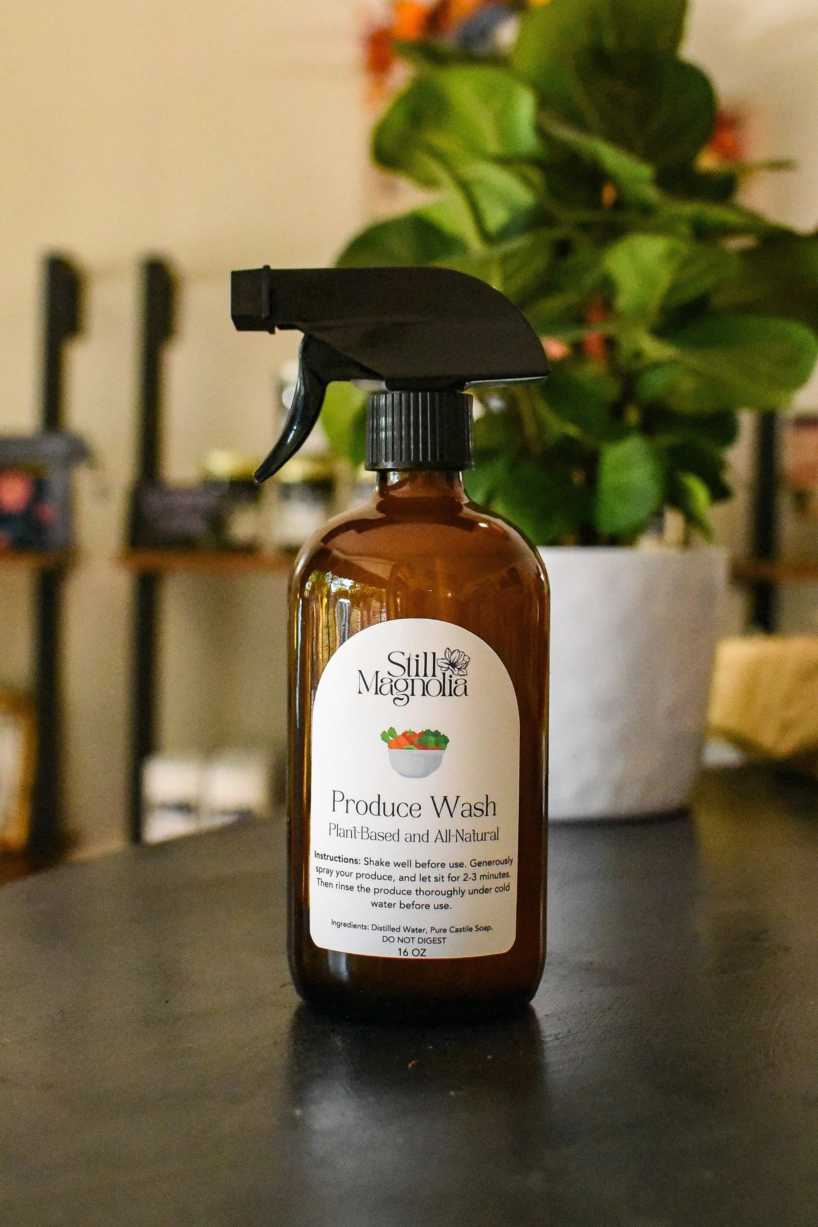 Still Magnolia plant-based produce wash in a 16 oz amber spray bottle.