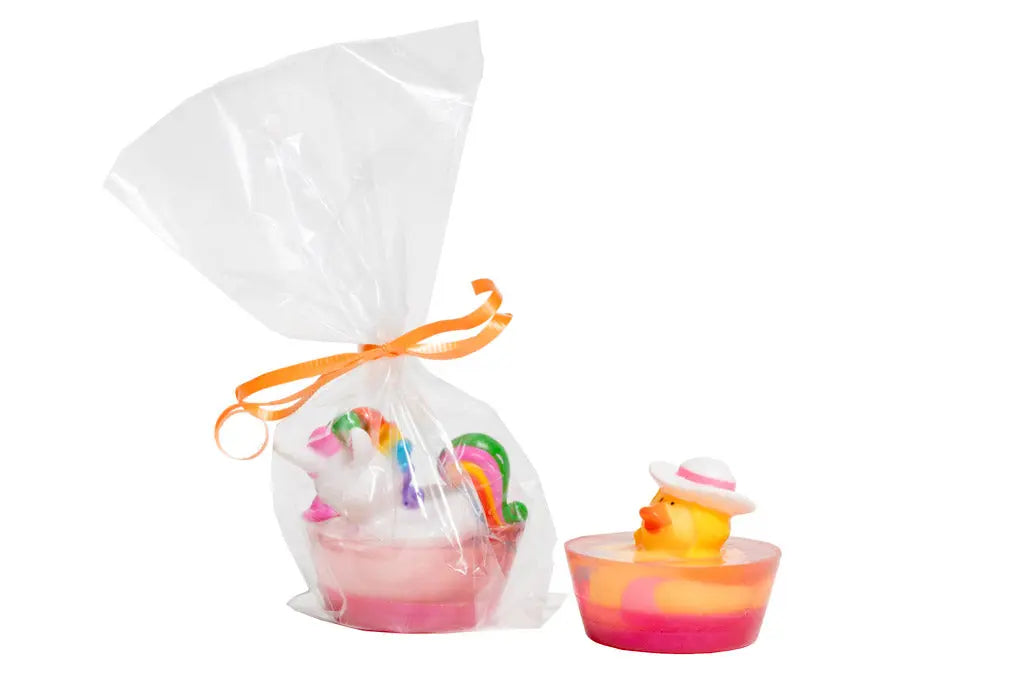 Rubber duck and unicorn soap bars in colorful bases, with unicorn soap in cellophane packaging.