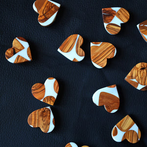 Heart-shaped ornaments with olive wood grain and white resin.