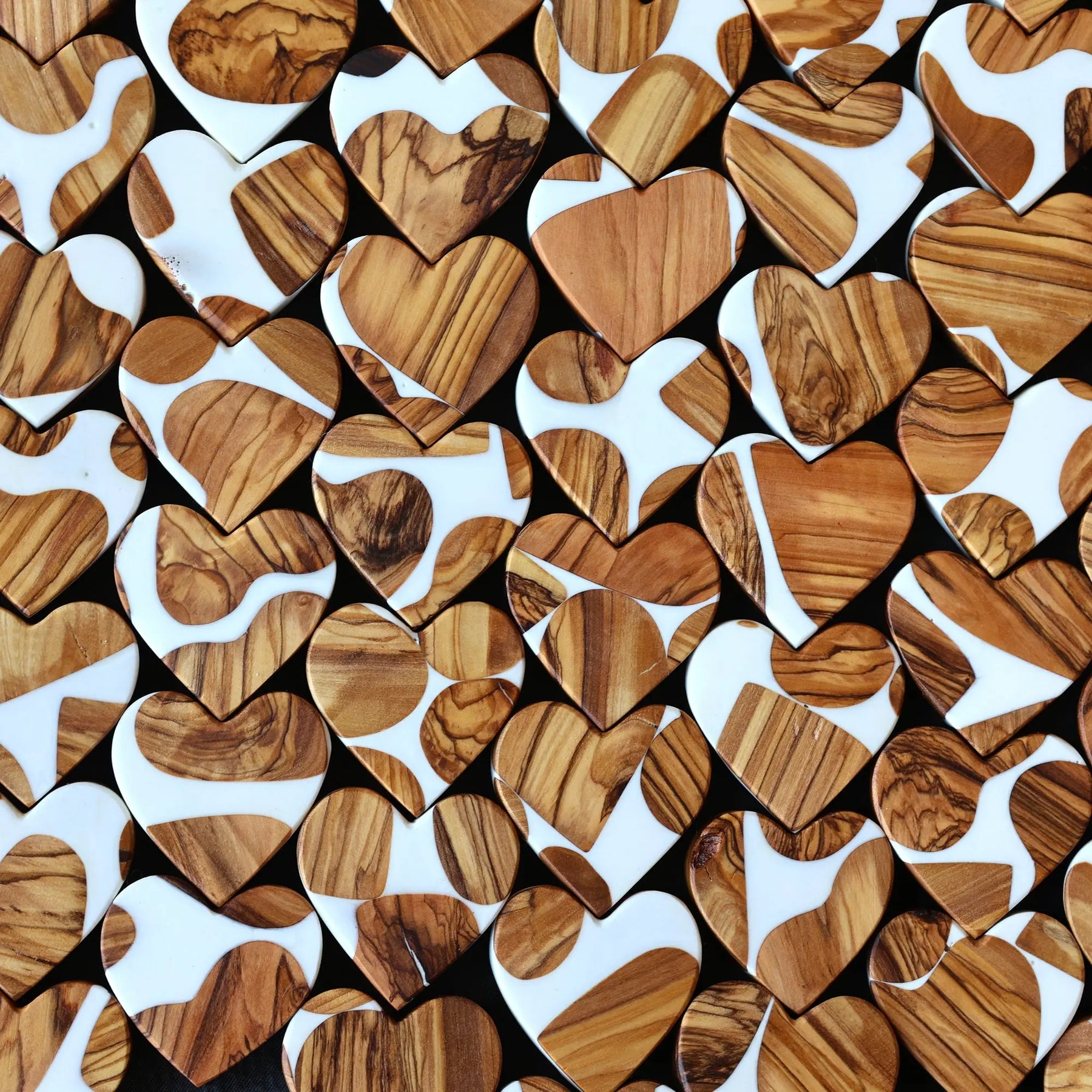 Heart-shaped objects with wood grain and white resin patterns.