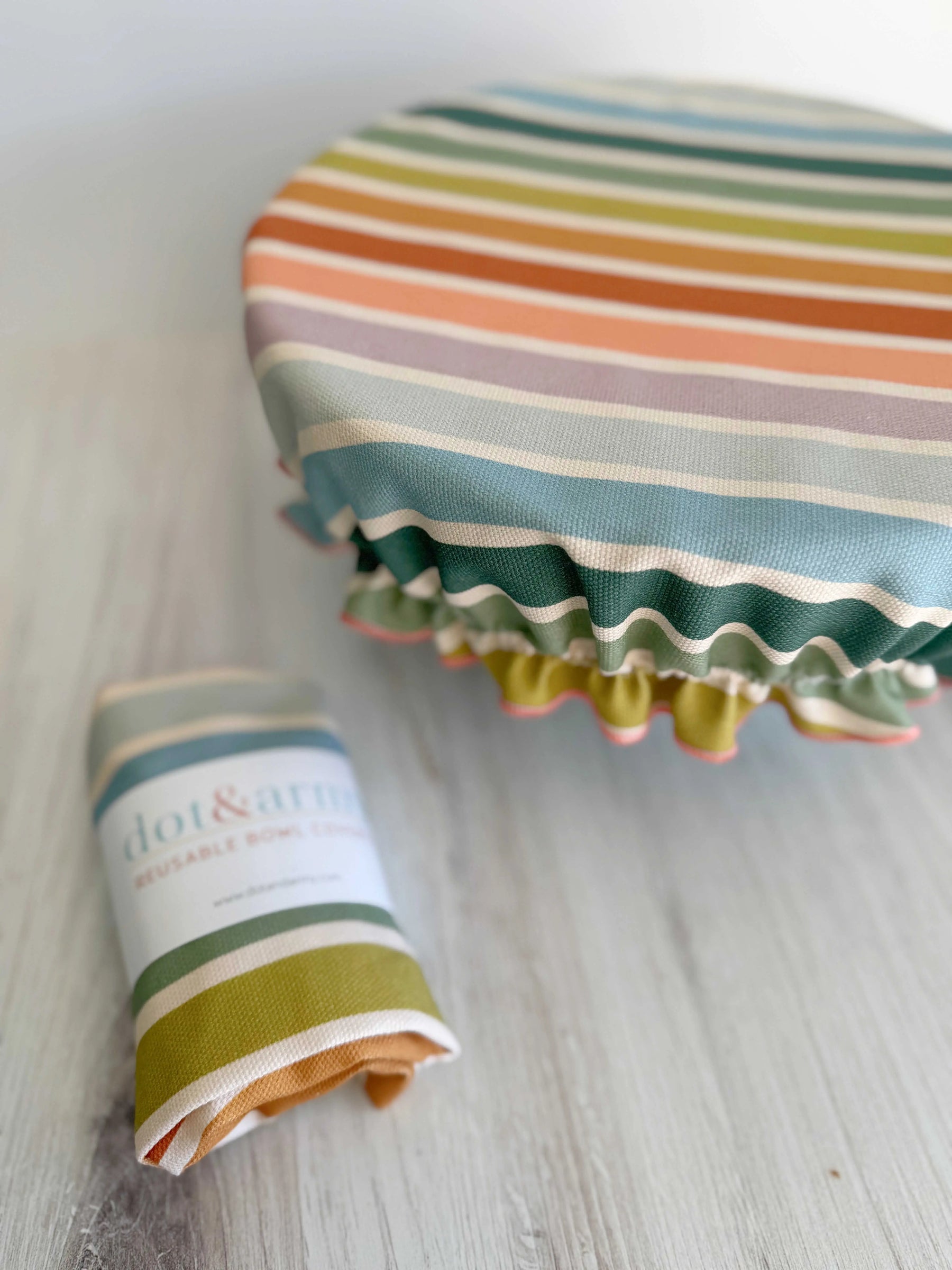 Reusable bowl cover with colorful rainbow stripes, featuring a 'Dot & Army' tag.