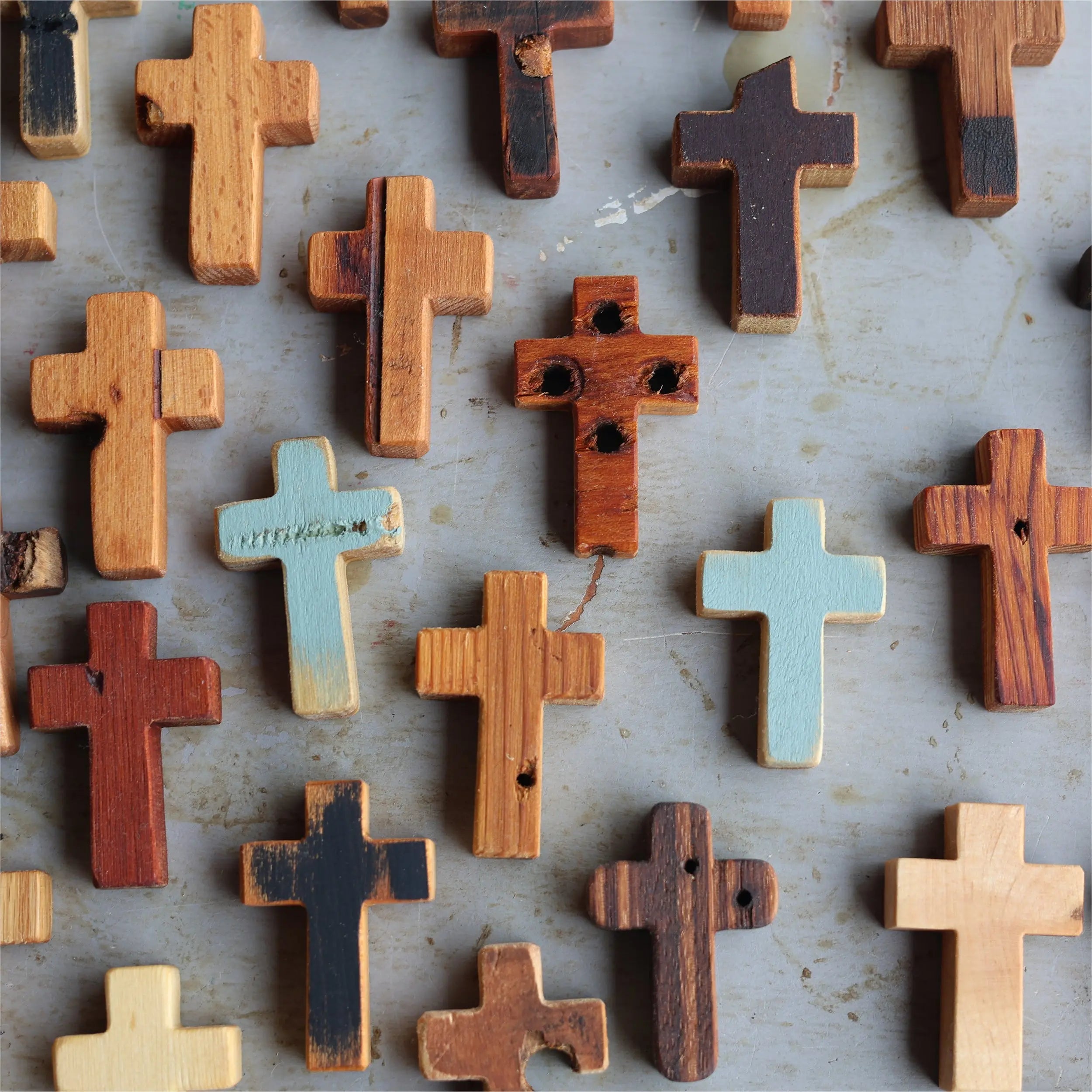 Assortment of wooden pocket crosses with varied finishes and textures.