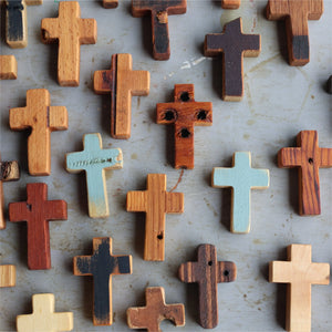 Assortment of wooden pocket crosses with varied finishes and textures.