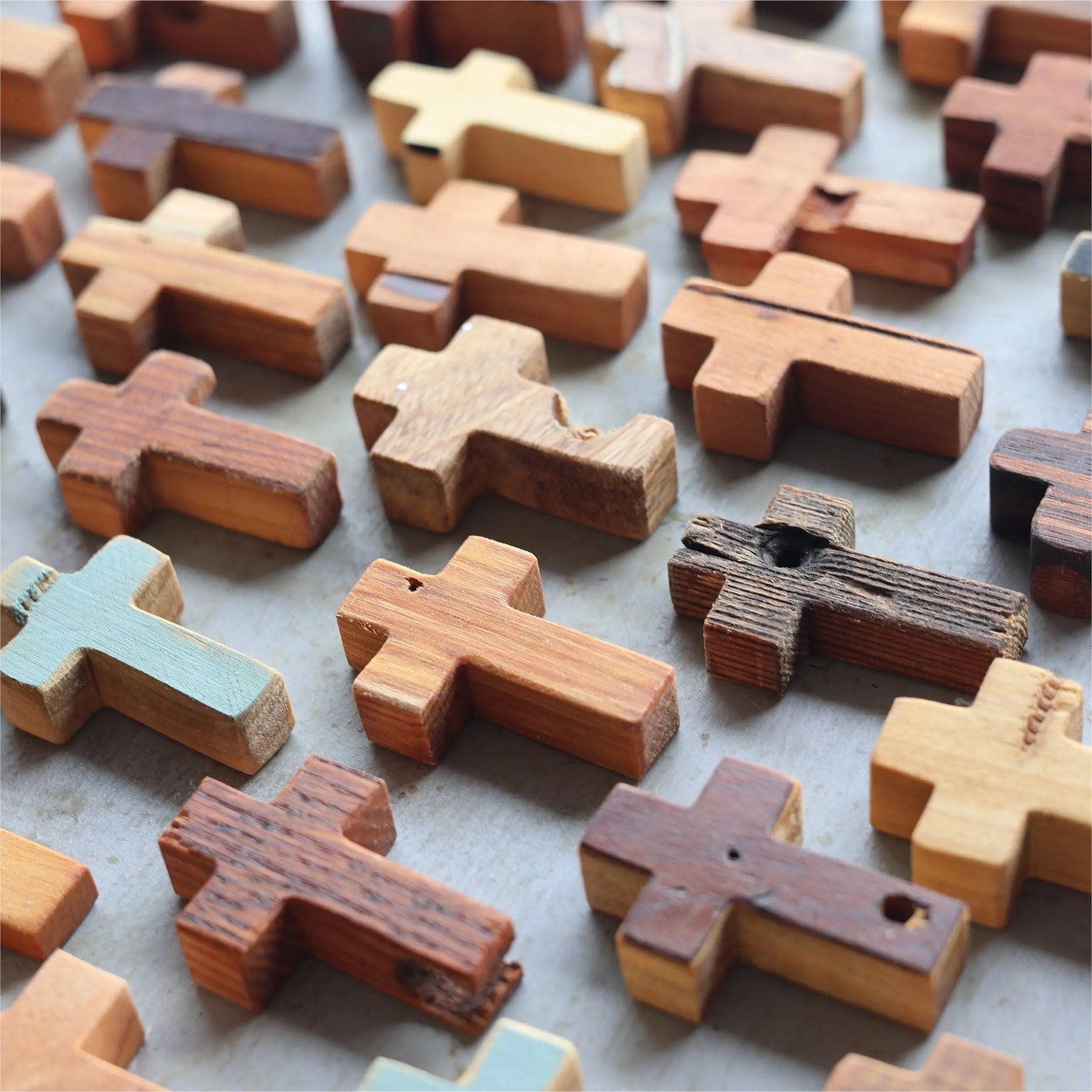 Collection of rustic wooden pocket crosses in various natural wood tones.