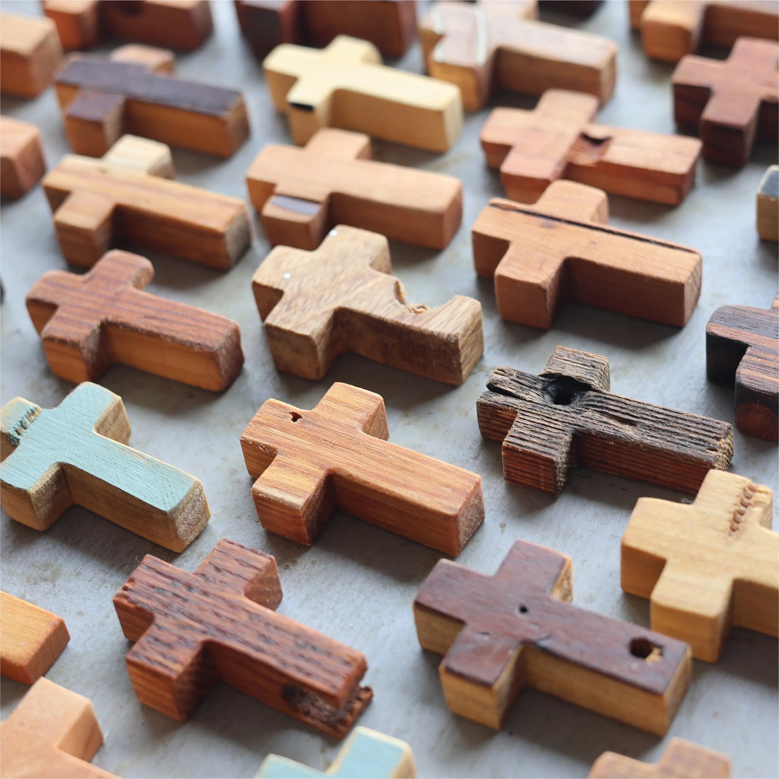 Collection of rustic wooden pocket crosses in various natural wood tones.