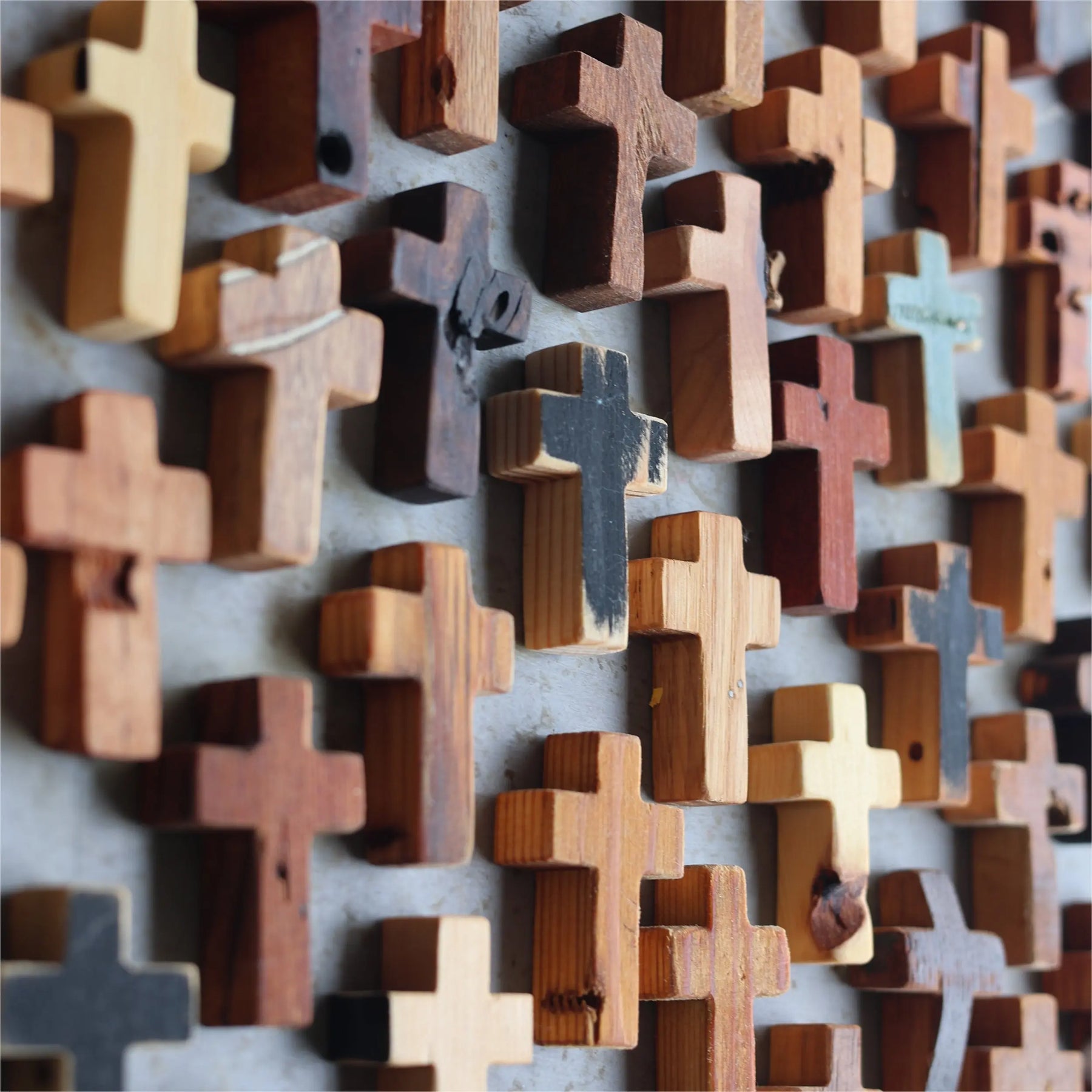 Handcrafted rustic wooden crosses with varied textures for wall decor.