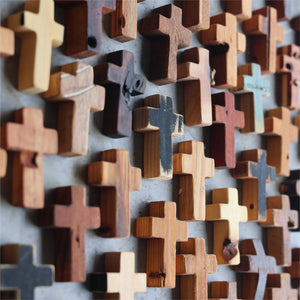Handcrafted rustic wooden crosses with varied textures for wall decor.