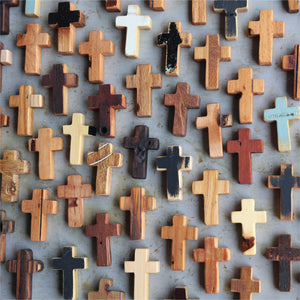 Assortment of rustic wooden pocket crosses in varied natural wood tones and painted finishes.