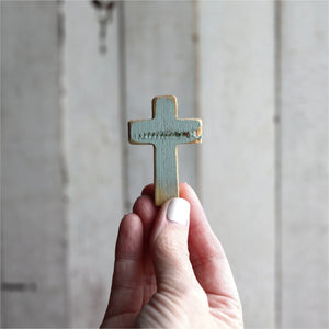 Small blue rugged pocket cross held in a hand