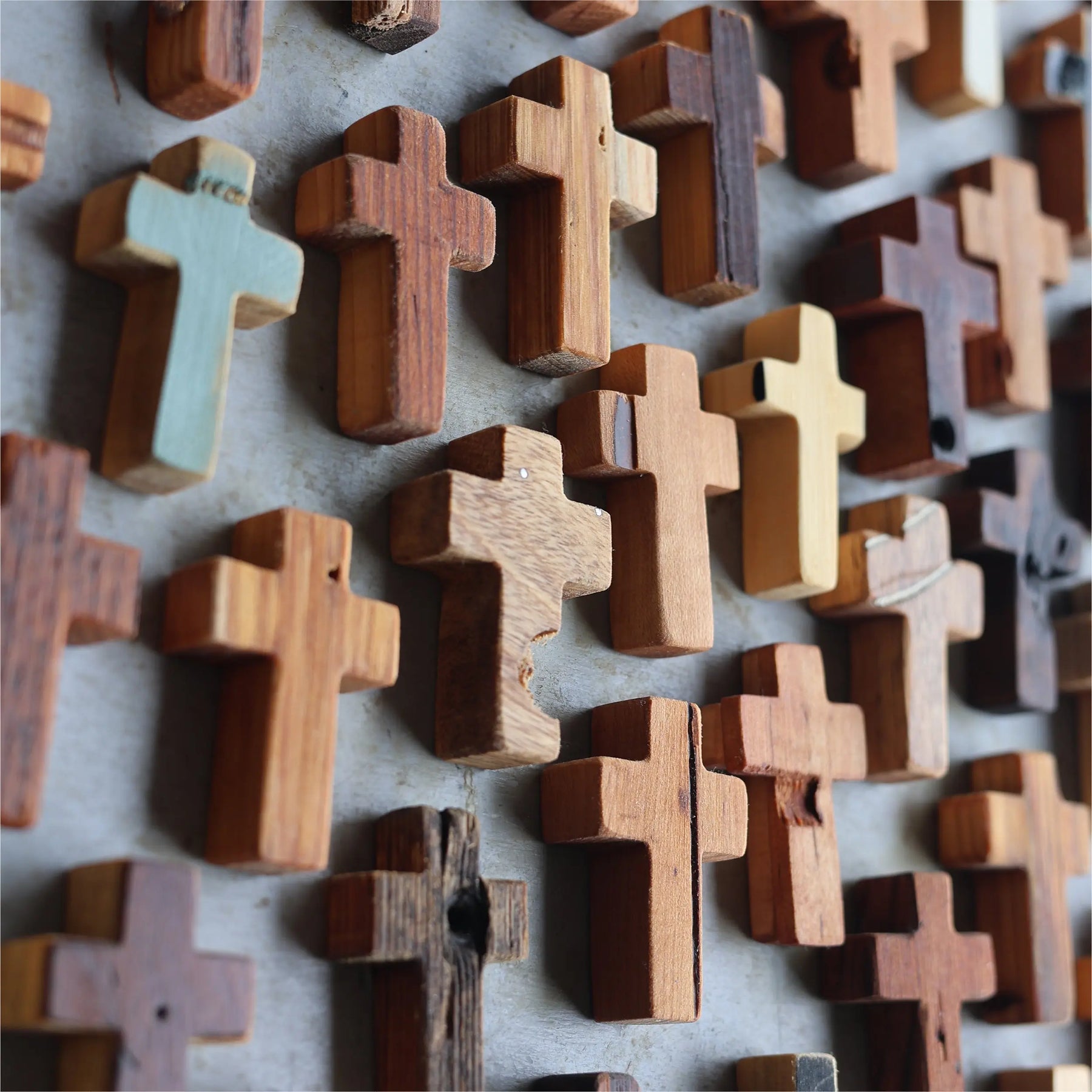 Assorted wooden pocket crosses with varied textures and shades
