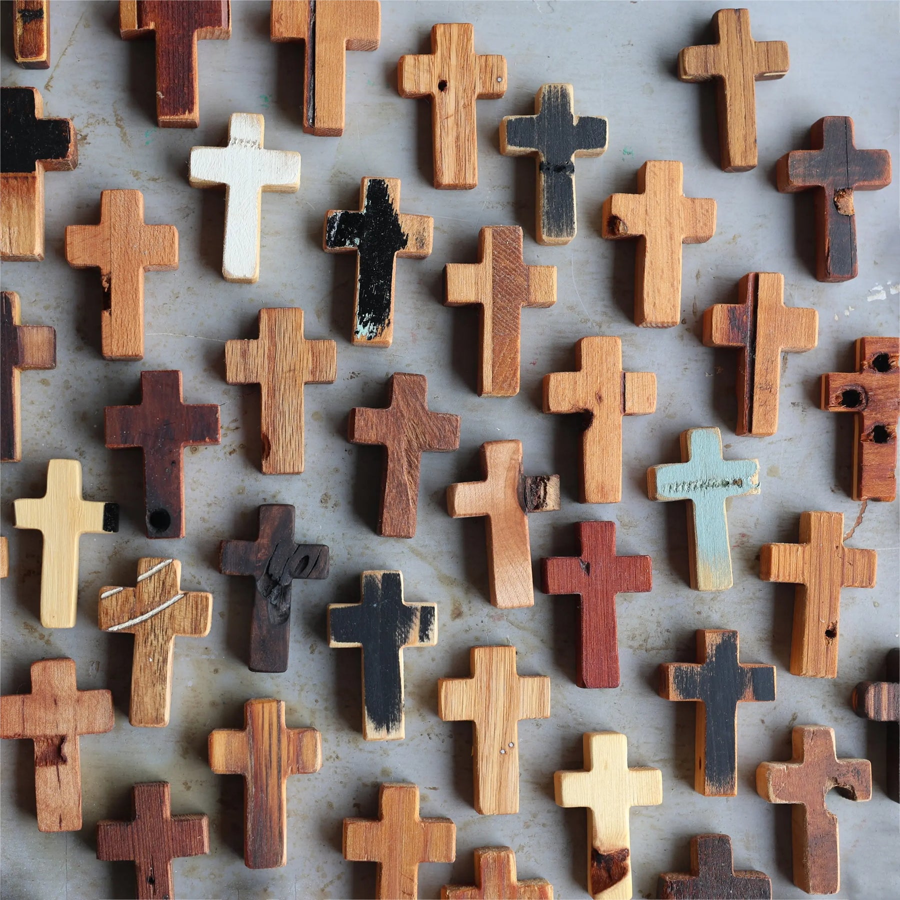 Collection of rustic wooden pocket crosses with varied natural wood grains and finishes.